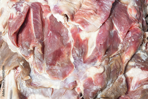 Fresh and raw sheep or lamb meat pieces for sale on the counter top of a butchery shop. photo