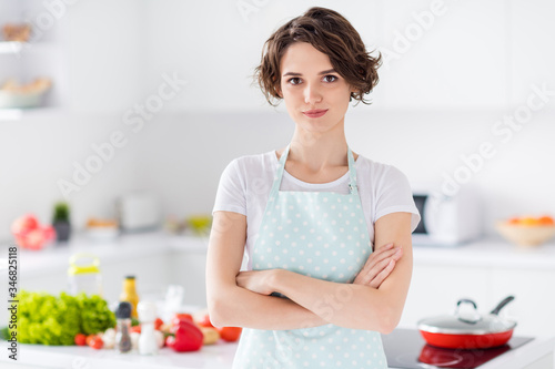 Photo of beautiful bobbed hairdo housewife holding arms crossed enjoy morning cooking tasty dinner family meeting wear apron t-shirt stand modern kitchen indoors