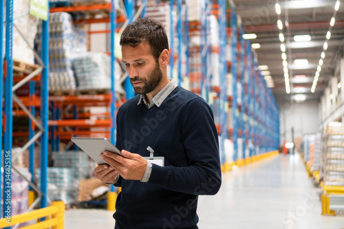 Manager holding digital tablet in warehouse 