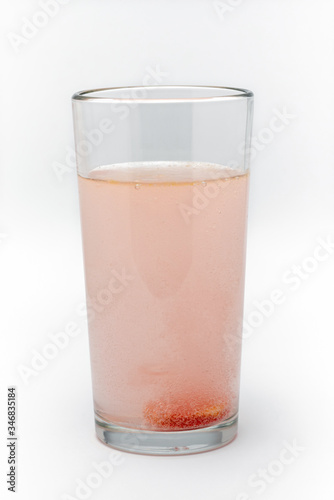 soluble effervescent multivitamin in a glass glass with water on a white background