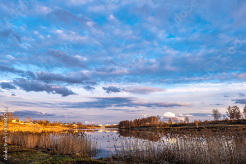 The bank of the river Uvod in the golden rays of the setting sun and beautiful clouds.