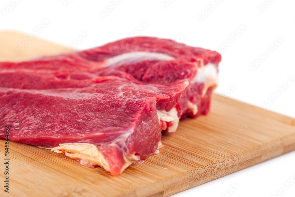 Raw meat on wooden board isolated on white background