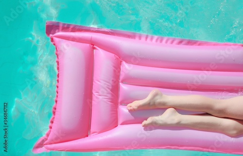 Woman legs in pink float  photo