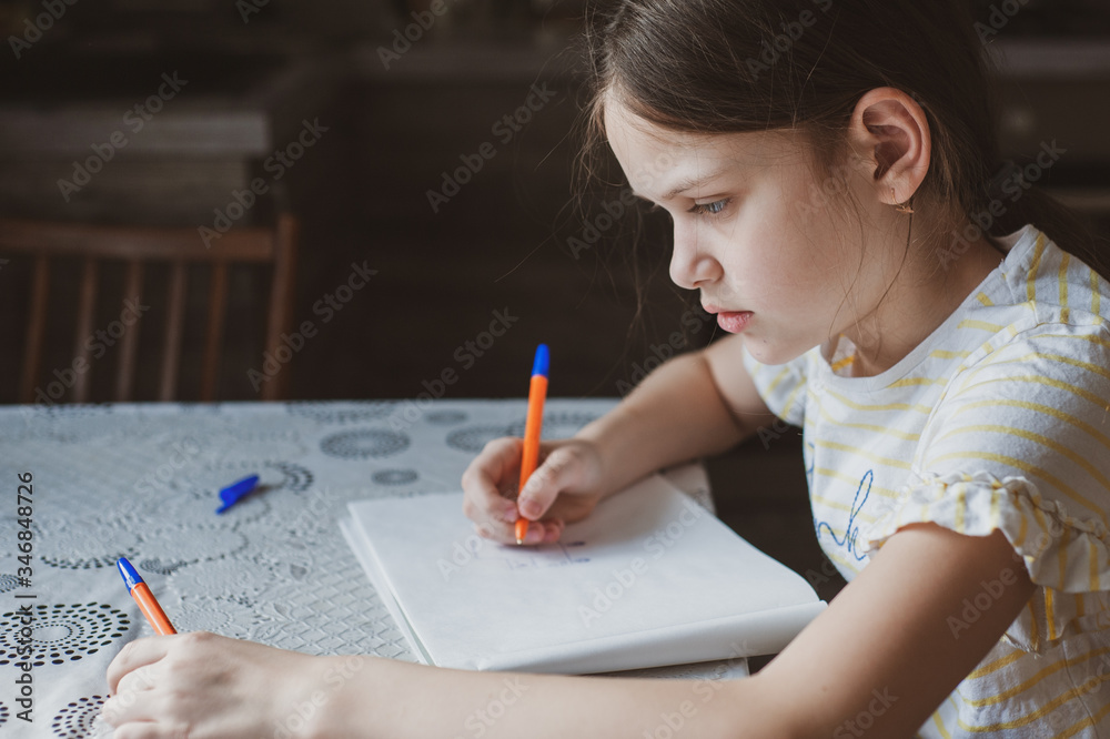 A teenager girl draws a pen in a sketchbook. Idea for quarantining a child A teenager girl draws a pen in a sketchbook. Idea for quarantining a child