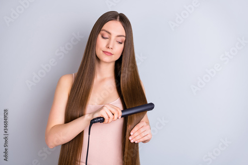 Close-up portrait of her she nice-looking attractive charming shine well-groomed brown-haired girl straightening smoothing hair isolated over light gray pastel color background