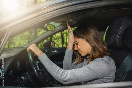 Foto Woman in car putting hands on head after a driving error or a crash
