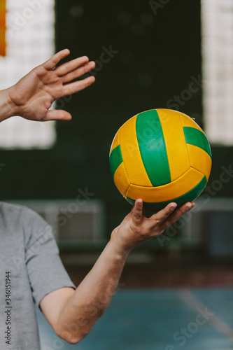 Striped ball in hands of volleyball player