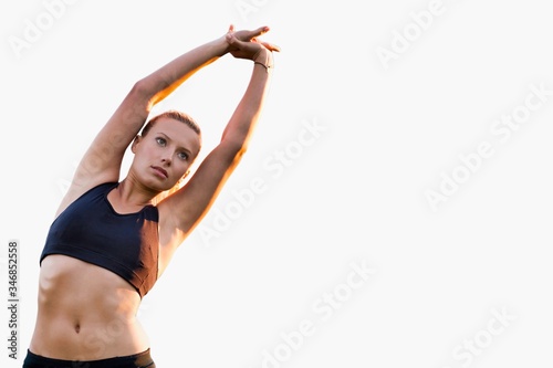Cutout of young attractive woman stretching in park © moodboard