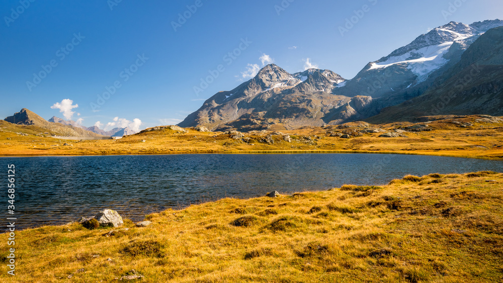 Sun is setting at Lej Pitschen, together with Lej Nair and Lago Bianco one of three lakes at The Bernina Pass. It connects Swiss Engadin valley with Val Poschiavo and ends in the Italian town Tirano