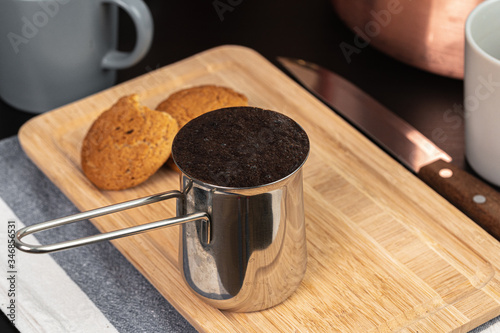 Brewed coffee in a metal turk on a kitchen counter close up photo