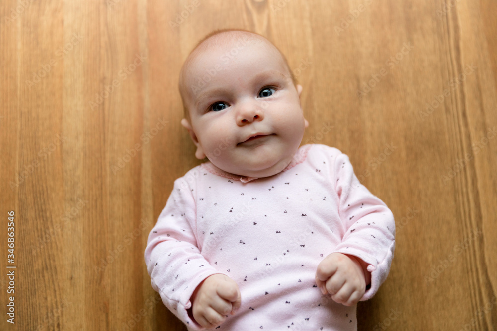 Newborn baby two-months-old smiles and lies on a white blanket. Psychomotor development and baby care Newborn baby two-months-old smiles and lies on a white blanket. Psychomotor development and baby care