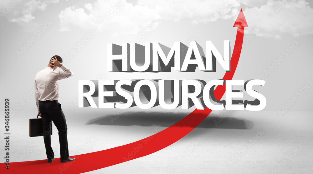 Rear view of a businessman standing in front of HUMAN RESOURCES inscription, successful business concept Rear view of a businessman standing in front of HUMAN RESOURCES inscription, successful business concept