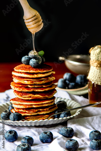 Homemade breakfast with delicious desserts of pancakes with fruit blueberries And there are honey drops on wooden table