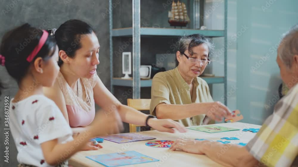 Multi generation of Asian family play board game together, Happy family time of daughter mother and grandparent playing in living room at home on holiday Multi generation of Asian family play board game together, Happy family time of daughter mother and grandparent playing in living room at home on holiday