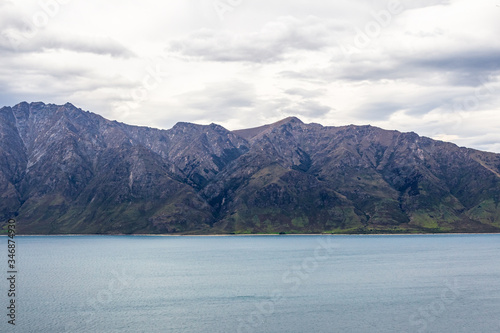 Snow-capped mountains on the banks of Hawea lake. South Island, New Zealand
