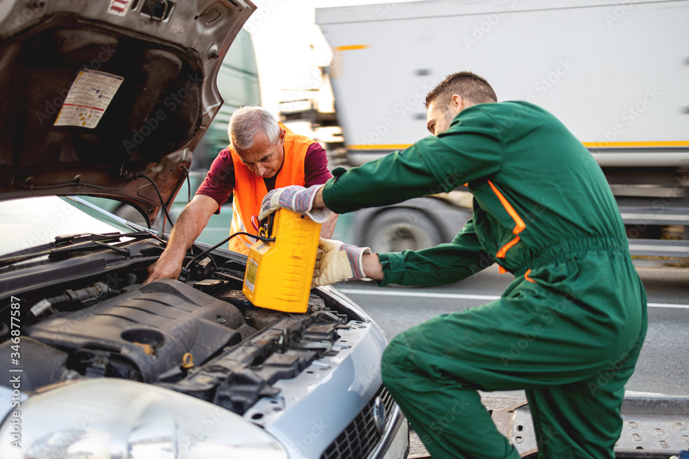 Repairers, transports a broken car on the road and fix problems on vehicle