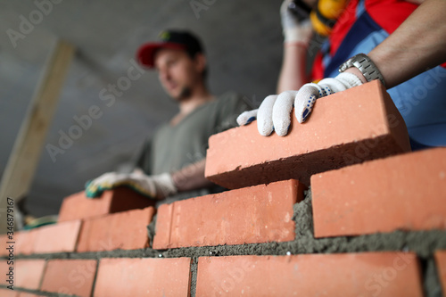 Fototapeta Builders make wall brick and cement, technology