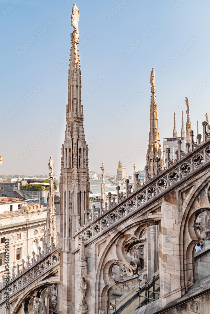 Ornate architectural marble statues and decoration on the roof of famous Cathedral Duomo di Milano in Milan, Lombardy, Italy