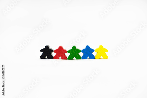 People for board games are on a white background. They are of different colors. Wooden toy people symbolize friendship, tolerance and unity. photo