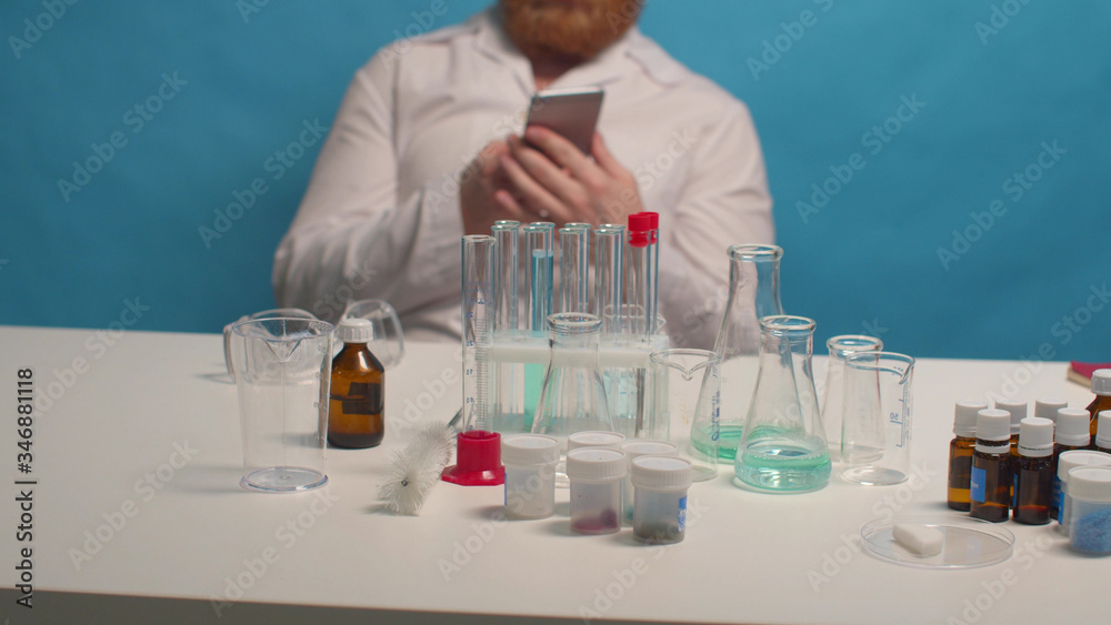 Fototapeta premium Chemist calls on the phone in the lab. Background