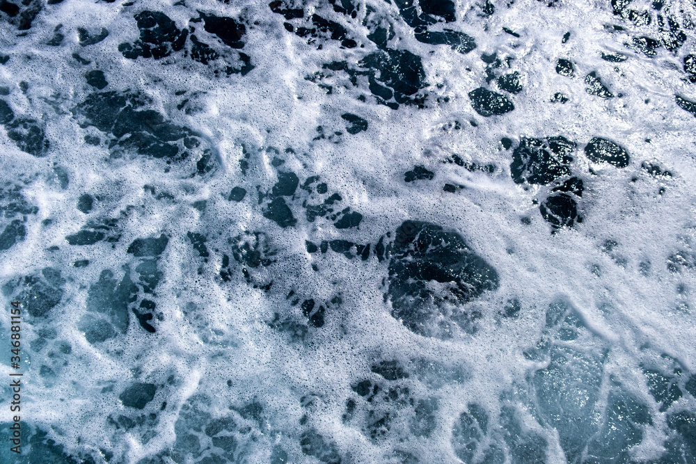 Top down aerial view of sea water surface. White foam waves texture as natural background.