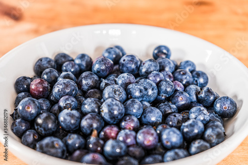 Fresh blueberries in a white bowl on a wooden table