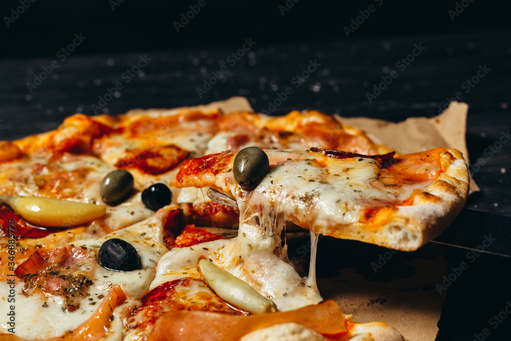 tasty pizza on wooden table, dark background