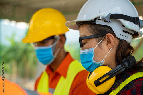 Engineer wearing protective mask to Protect Against Covid-19 working at construction site,Architect Engineer Meeting People Brainstorming Concept. photo