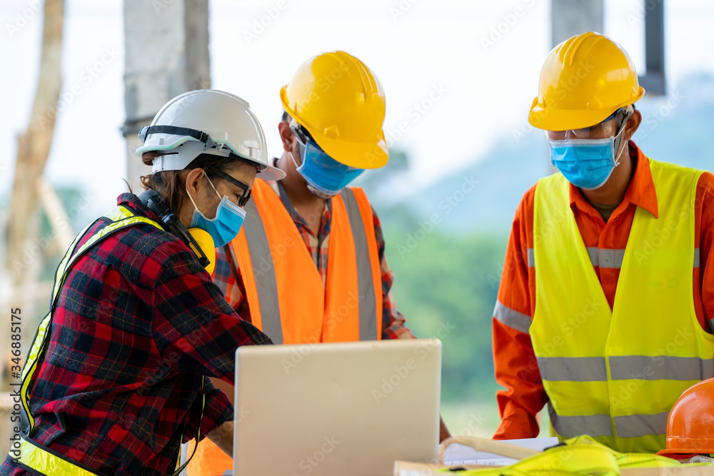 Engineer wearing protective mask to Protect Against Covid-19 working at construction site,Architect Engineer Meeting People Brainstorming Concept. Engineer wearing protective mask to Protect Against Covid-19 working at construction site,Architect Engineer Meeting People Brainstorming Concept.