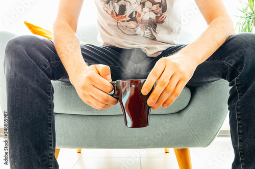 Man coffee cup in blue armchair