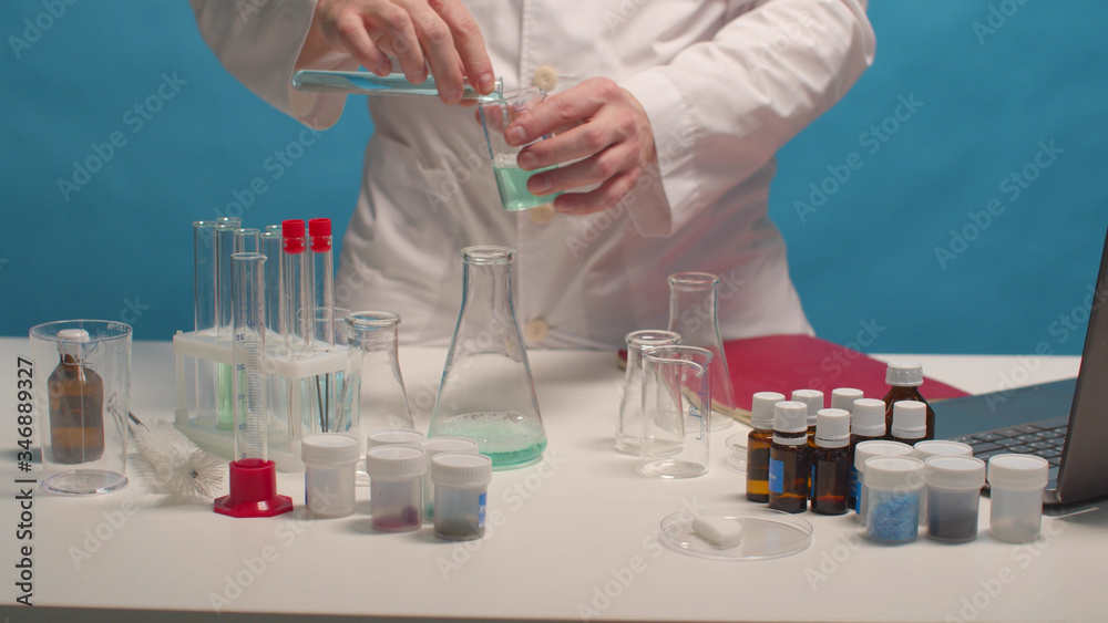 Fototapeta premium Scientist mixes alkali and acid in flasks