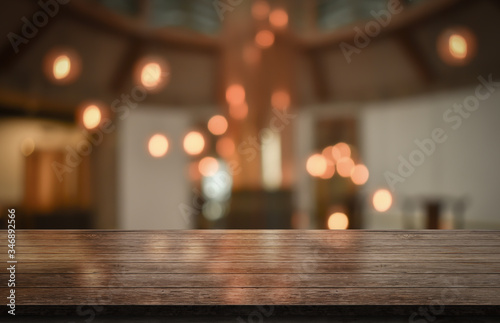 Empty wooden table top with lights bokeh on blur restaurant background, 3D Rendering © DEEP PIXEL