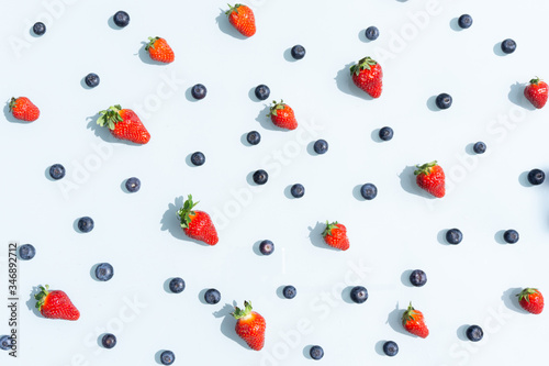 Fototapeta Naklejka Na Ścianę i Meble -  Fruit pattern of blueberries and strawberries. Blue background flatlay