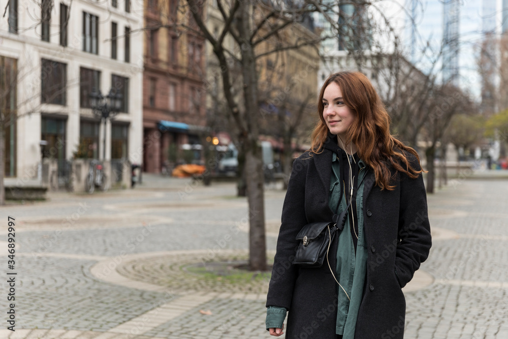 Young Woman Posing in Pedestrian Zone with Head Turned