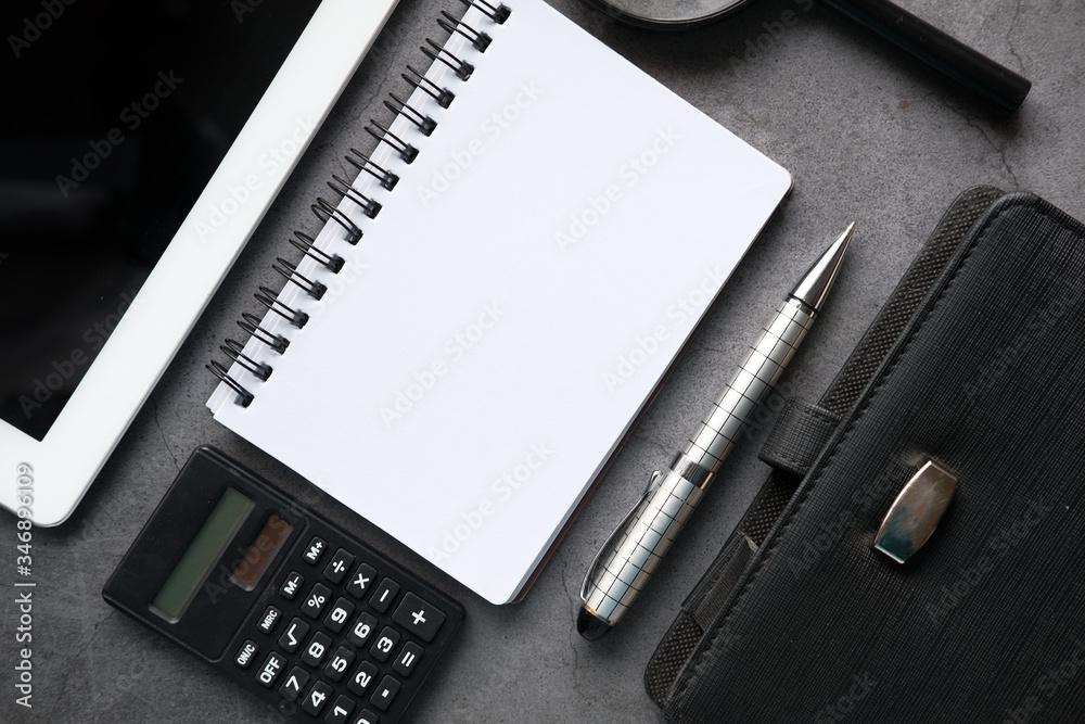 Top view of notepad, digital tablet and pen on black background 