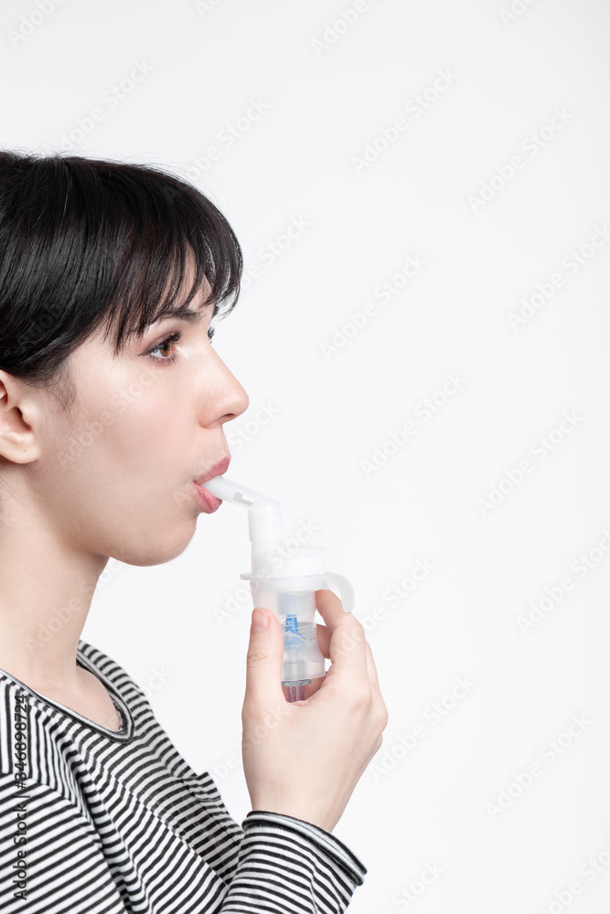 profile picture of brunette woman using inhaler. patient inhale medicine . closeup profile picture of brunette woman using inhaler. patient inhale medicine . closeup