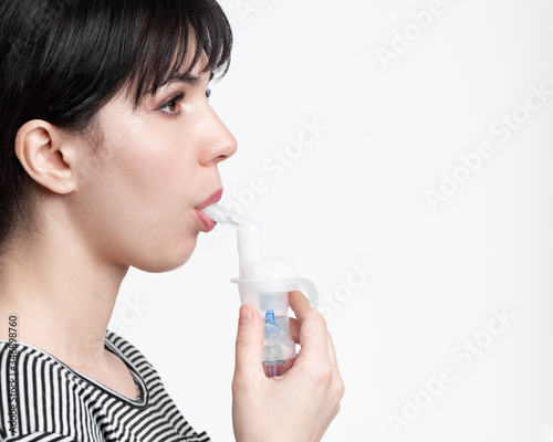 profile picture of brunette woman using inhaler. patient inhale medicine