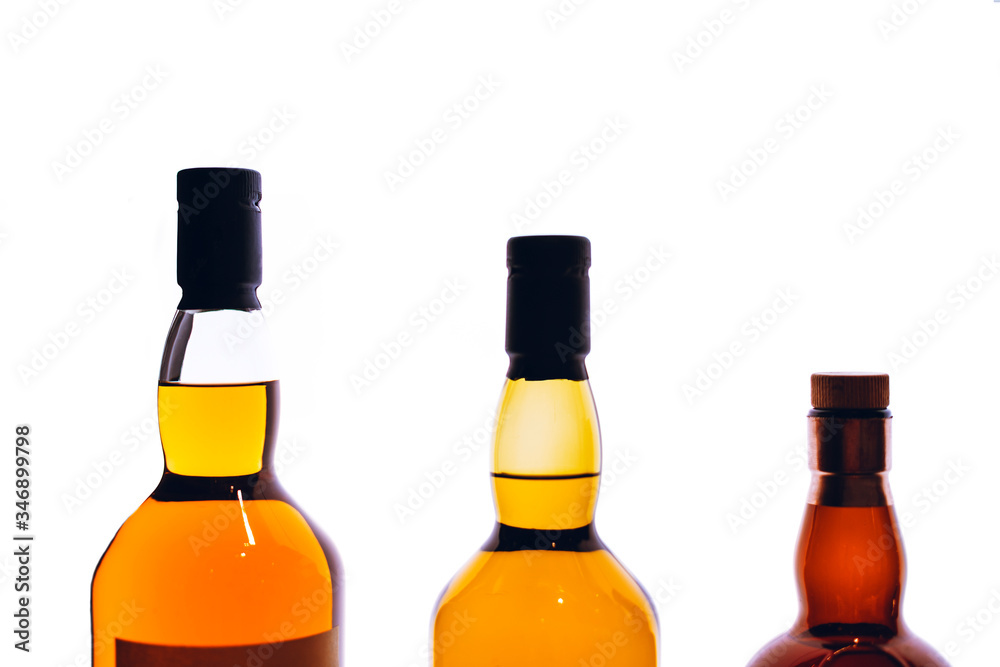 Bottles of expensive alcohol on the white background. Copy space included. Bottles of expensive alcohol on the white background. Copy space included.