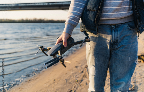 A quadcopter in the hands of a guy on the beach