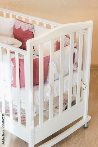 Fototapeta Naklejka Na Ścianę i Meble -  Baby bed crib with white and Burgundy color pillows with laces