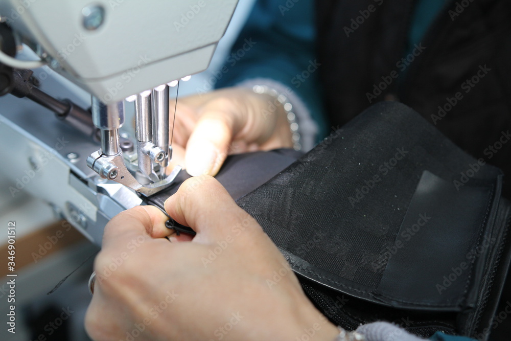 sew the components of a leather bag in factory