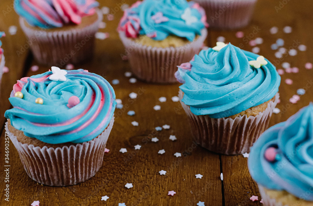 Pink and blue cupcakes on a natural wooden background