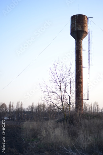 old rusty water tower against spring sky