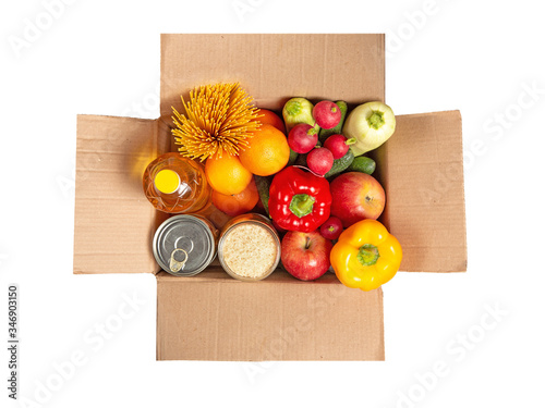 Fototapeta Naklejka Na Ścianę i Meble -  Cardboard box with a set of food on a white isolated background. Fruits, vegetables, canned food, vegetable oil, spaghetti. Food delivery. Grocery set.