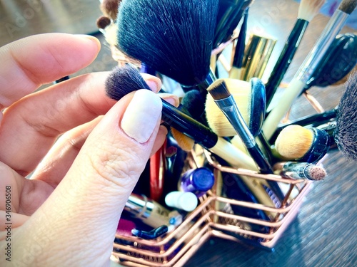 hands of a woman holdind cosmetic brashes photo