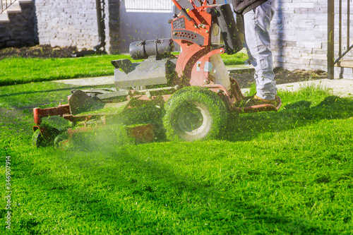 Lawn mower cutting the grass gardening activity own home yard with lawn mower photo