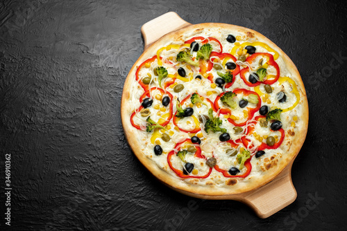 Vegan Pizza VIRGINIA on a black background, cream-based combined with broccoli, capers, olives, corn, sweet peppers and onions