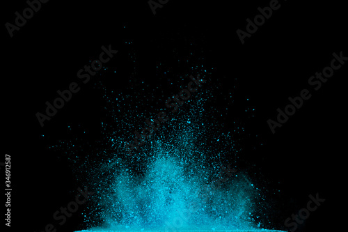 Explosion of blue, aqua and violet dust on black background.
