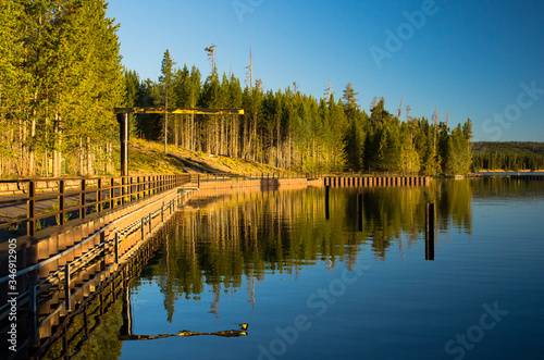 Fototapeta Naklejka Na Ścianę i Meble -  Reflection of trees in a beautiful lake during sunrise