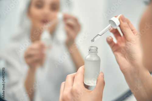 Pretty Caucasian lady holding face care product